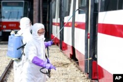 Members from an emergency anti-epidemic headquarters in Mangyongdae District, disinfect a tramcar of Songsan Tram Station to prevent new coronavirus infection in Pyongyang, North Korea, Feb. 26, 2020.