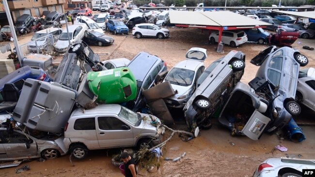 Vehículos arrastrados por las apilados en una calle de Paiporta, en el área de Valencia, España, después de históricas inundaciones, el 31 de octubre de 2024.