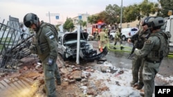 اسرائیلی پولیس اہلکار اور ریسکیو اہلکار 9 اکتوبر 2023 کو مقبوضہ مغربی کنارے کے کے ایک قصبے بیطار الیت میں غزہ سے راکٹ حملے کے بعد جائزہ لیتے ہوئے۔
