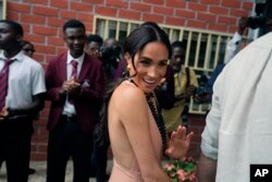 FILE—Meghan Markle gestures as she and Prince Harry visit children at the Lights Academy in Abuja, Nigeria, May 10, 2024.