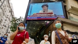 A TV screen broadcasts Hong Kong Chief Executive Carrie Lam during a news conference in Hong Kong, Tuesday, March 30, 2021. China's top legislature approved amendments to Hong Kong's constitution on Tuesday that will give Beijing more control over…