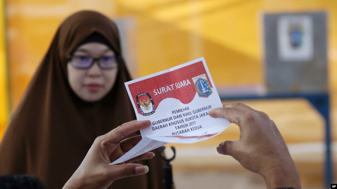 Seorang petugas pemungutan suara memeriksa surat suara saat putaran kedua pilgub Jakarta, 19 April 2017. (Foto: Associated Press)