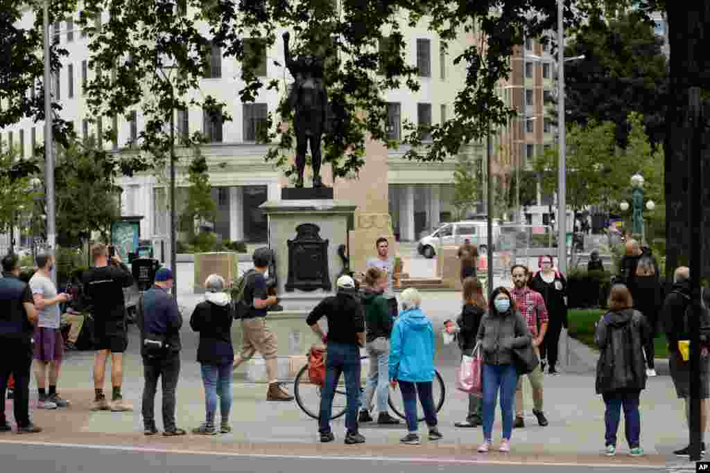 People look at a statue of a Black Lives Matter protester by British artist Marc Quinn erected in the spot once occupied by the statue of a slave trader in the English city of Bristol.&#160;