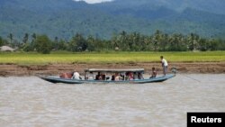 Wara etnis Rohingya mengungsi dengan perahu melewati sungai Buthidaung, Myanmar (foto: ilustrasi). Sedikitnya tiga perahu yang mengangkut pengungsi Rohingya dari Myanmar ke Bangladesh tenggelam, menewaskan 26 orang. 