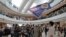 Protesters hold a British National (Overseas) passport and Hong Kong colonial flag in a shopping mall during a protest against China's national security legislation for the city, in Hong Kong, Friday, May 29, 2020.