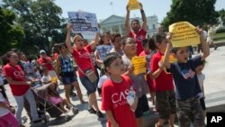 Demonstrators march following a news conference of immigrant families and children's advocates responding to President Barack Obama's position on the crisis of unaccompanied children and families illegally entering the US, in front of the White House in W