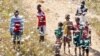 Local youth and children stand in a swarm of locust flying over in Soatana village, southern Madagascar on May 29, 2011.