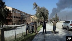 Polisi federal Irak merayakan kemenangan mereka saat berada di lokasi antara bandara dan pabrik gula di Mosul barat, Irak, 24. Februari 2017. (AP Photo/ Khalid Mohammed).