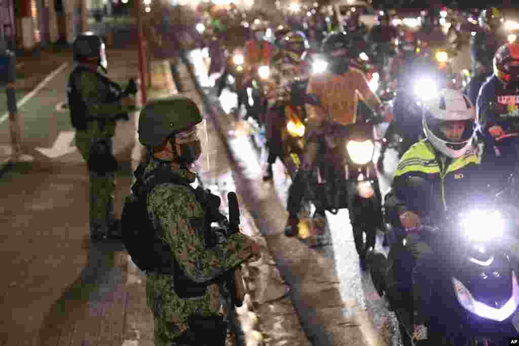 Polis əməkdaşları Filippinin Marikina şəhərinin kənarında koronavirusun yayılmasının qarşısını almaq üçün gücləndirilmiş məhdudiyyətlər fonunda yoxlama aparır