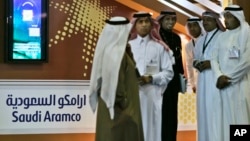 FILE - Employees of the Saudi Aramco oil company prepare for the first day of the Arab Oil and Gas exhibition in Dubai, United Arab Emirates. 