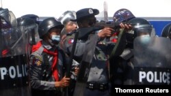 La policía en Naipyidó, capital de Myanmar, dispersa el martes 9 de febrero de 2021 con disparos a los manifestantes que protestan por el golpe militar que derrocó a la líder de facto Aung San Suu Kyi.