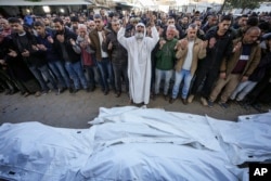 Palestinians pray over the bodies of the victims of an Israeli strike on a home late Saturday before the funeral outside the Al-Aqsa Martyrs Hospital in Deir al-Balah, Dec. 22, 2024.