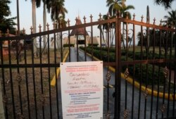 A sign hanging on a locked gate in front of the Ermita de la Caridad church in Miami indicates that the church is closed during the new coronavirus pandemic, April 9, 2020.