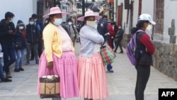 TOPSHOT - Women wear facemasks, amid concerns over the spread of the COVID-19 coronavirus, as they queue in front of a bank in Puno, Peru on October 5, 2020. - The Peruvian government relaxed confinement measures for older adults and lifted the…