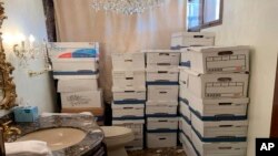 ARCHIVO: Esta imagen, que forma parte de la acusación al expresidente Donald Trump, muestra cajas de documentos en un baño de la finca Mar-a-Lago de Trump en Palm Beach, Florida.