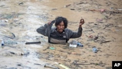 A man wades through flood water following heavy downpours in Medan, North Sumatra, Indonesia. (AP Photo/Binsar Bakkara)