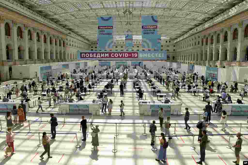 People wait in line for a COVID-19 vaccine at a vaccination center in Gostinny Dvora, a huge exhibition place in Moscow, Russia, as the country faces a sharp surge in coronavirus cases.