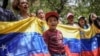 Manifestantes con una bandera venezolana se concentran en el consulado de Venezuela en Bogotá para protestar contra los resultados de las controvertidas elecciones presidenciales que dieron por ganador a Nicolás Maduro, el jueves 1 de agosto de 2024. 