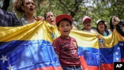 Manifestantes con una bandera venezolana se concentran en el consulado de Venezuela en Bogotá para protestar contra los resultados de las controvertidas elecciones presidenciales que dieron por ganador a Nicolás Maduro, el jueves 1 de agosto de 2024. 