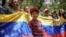 Manifestantes con una bandera venezolana se concentran en el consulado de Venezuela en Bogotá para protestar contra los resultados de las controvertidas elecciones presidenciales que dieron por ganador a Nicolás Maduro, el jueves 1 de agosto de 2024. 