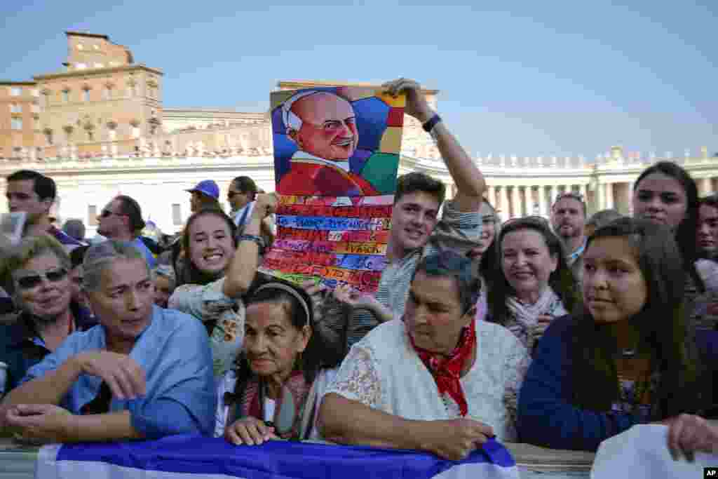 Los fieles siguen una ceremonia de canonización en la Plaza de San Pedro en el Vaticano, el domingo 14 de octubre de 2018. El Papa Francisco canonizó a dos de las figuras más importantes y disputadas de la Iglesia Católica del siglo XX, declarando al Papa Paulo VI y al asesinado arzobispo salvadoreño Óscar Romero como modelos de santidad para los fieles de hoy. (Foto AP / Andrew Medichini)