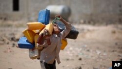 Seorang anak laki-laki membawa jerigen untuk diisi air dari sumber air publik di tengah langkanya persediaan air, di pinggir kota Sana'a, Yaman (13/10). (AP/Hani Mohammed)