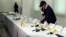 Official with the Central Bureau of Judicial Investigation gestures toward confiscated weapons in Sale, Morocco, Sept. 14, 2015.