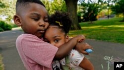 Zavion Guzman hugs his sister Jazzmyn, June 30, 2021, in Belleville, NJ. Lunisol Guzman adopted the two as babies but died last year from COVID-19 along with her partner at the start of the violent first wave of the pandemic.