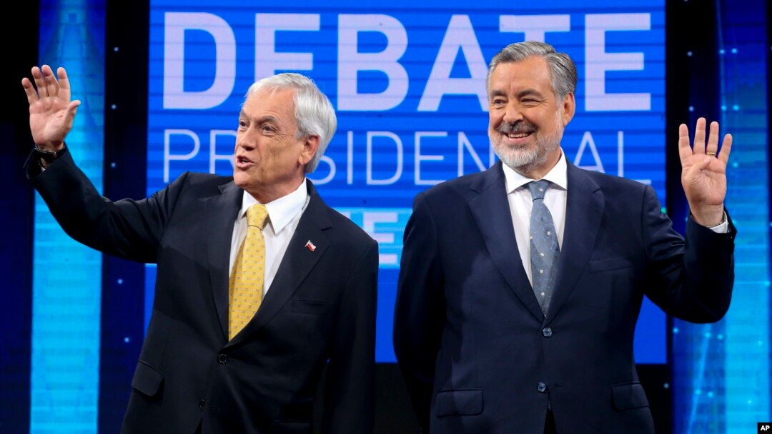 Chile Vamos candidate and former President Sebastian Pinera, left, and Nueva Mayoria or New Majority ruling party candidate Alejandro Guillier, pose for photos before the start of a live, televised presidential debate, in Santiago, Chile, Dec. 11, 2017.