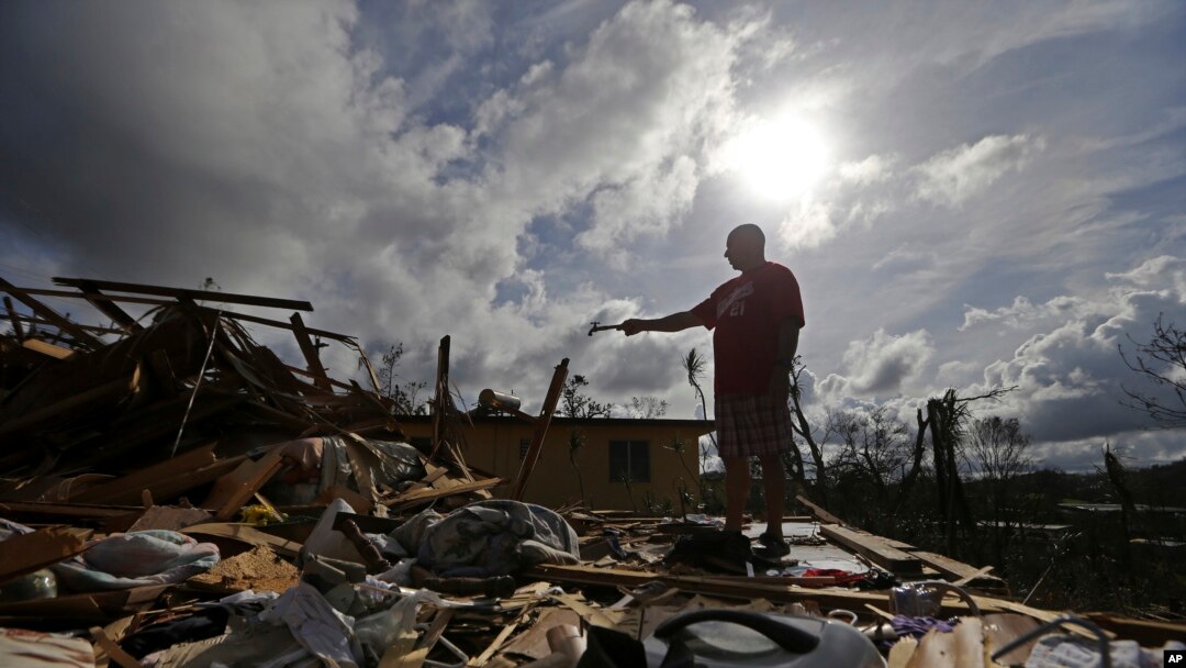 Jose Garcia Vicente holds a piece of plumbing he picked up, as he shows his destroyed home, in the aftermath of Hurricane Maria, in Aibonito, Puerto Rico, Monday, Sept. 25, 2017.