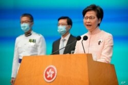 La directora ejecutiva de Hong Kong, Carrie Lam, a la derecha, habla además del secretario en jefe John Lee, en el centro, y el comisionado de policía Raymond Siu durante una conferencia de prensa en Hong Kong, el 25 de junio de 2021.