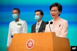 La directora ejecutiva de Hong Kong, Carrie Lam, a la derecha, habla además del secretario en jefe John Lee, en el centro, y el comisionado de policía Raymond Siu durante una conferencia de prensa en Hong Kong, el 25 de junio de 2021.