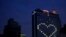 A downtown hotel leaves lights on in vacant room windows to form a heart Friday, March 27, 2020, in Kansas City, Mo.