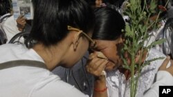 A Cambodian Khmer Rouge victim, right, weeps during a Buddhist ceremony near Choeung Ek stupa, the site of the Khmer Rouge's former "killing fields," on the outskirts of Phnom Penh, Cambodia, Sunday, Nov. 20, 2011.