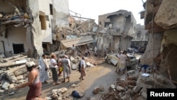 People gather at the site of a Saudi-led air strike in the Red Sea port city of Hodeidah, Yemen, Sept. 22, 2016. 