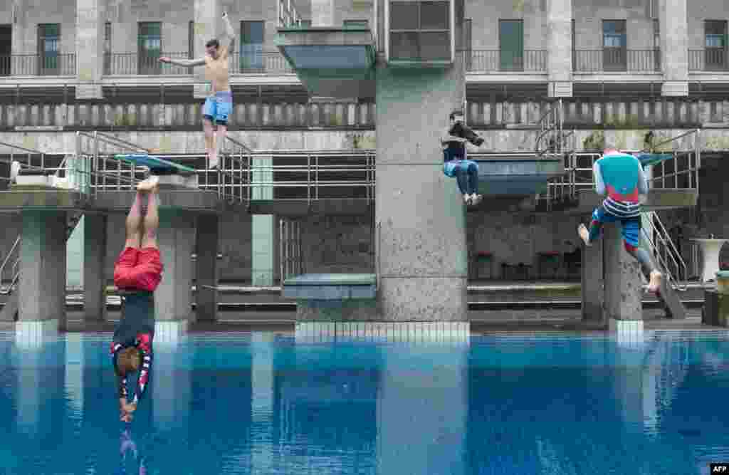 Splash divers jump into the water of the Sommerbad Olympiastadion public swimming pool in Berlin, during an event to promote the German capital&#39;s open-air pools.