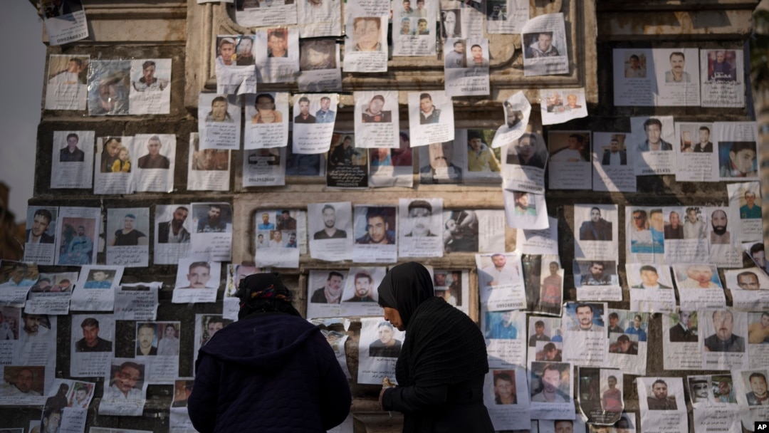 Warga mengamati kumpulan foto dari orang-orang yang dilaporkan hilang di tangan tentara Presiden Bashar al-Assad', di alun-alun Marjeh di Damaskus, pada 22 Desember 2024. (Foto: AP/Leo Correa)