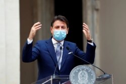 Italian Prime Minister Giuseppe Conte wearing a protective face mask gestures as he speaks during a news conference on government's new anti-COVID-19 measures, at Chigi Palace in Rome, Oct. 25, 2020.