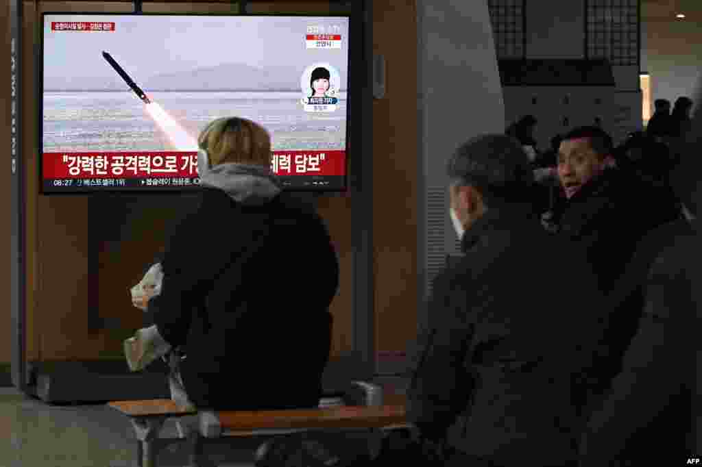 People watch a television screen showing news footage of North Korea&#39;s latest test-launch of strategic cruise missiles, at a train station in Seoul.