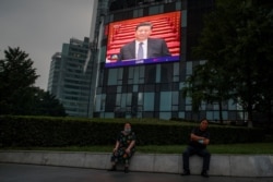 FILE - A screen at a department store shows Chinese President Xi Jinping during the opening session of the Chinese People's Political Consultative Conference at the Great Hall of the People in Beijing, China, May 21, 2020.