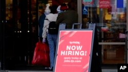 FILE - A hiring sign is displayed outside of a retail store in Vernon Hills, Ill., Nov. 13, 2021. 