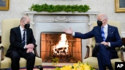 President Joe Biden, right, gestures during a meeting with German Chancellor Olaf Scholz in the Oval Office of the White House, in Washington, Feb. 7, 2022.