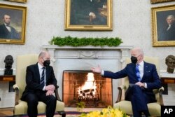 FILE - President Joe Biden, right, gestures during a meeting with German Chancellor Olaf Scholz in the Oval Office of the White House, in Washington, Feb. 7, 2022.