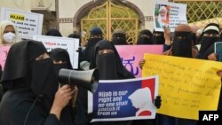Muslim women hold placards during a demonstration after educational institutes in Karnataka denied entry to students for wearing hijabs, in Bangalore, Feb. 7, 2022. 