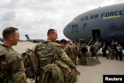 Military personnel from the 82nd Airborne Division and 18th Airborne Corps board a C-17 transport plane for deployment to Eastern Europe, amid escalating tensions between Ukraine and Russia, at Fort Bragg, North Carolina, Feb. 3, 2022.