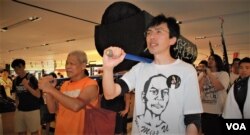 现年75岁的香港社运人士 古思尧 (左)2013年5月26日参与前学民思潮平反六四游行，与社民连前主席吴文远，抬着道具棺材游行经过一间百货公司 (美国之音汤惠芸)
