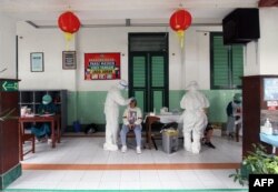 Tenaga medis melakukan tes swab PCR Covid-19 di sebuah sekolah di Solo, Jawa Tengah pada 7 Februari 2022. (Foto: AFP/Dika)