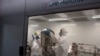 FILE - Employees at the Afrigen biotechnology company and vaccine hub facility work in the manufacturing laboratory in Cape Town, Oct. 5, 2021.