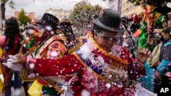 Una mujer con un protector facial para frenar la propagación del nuevo coronavirus actúa durante la inauguración de las celebraciones del Carnaval en La Paz, Bolivia, el 6 de febrero de 2022. 