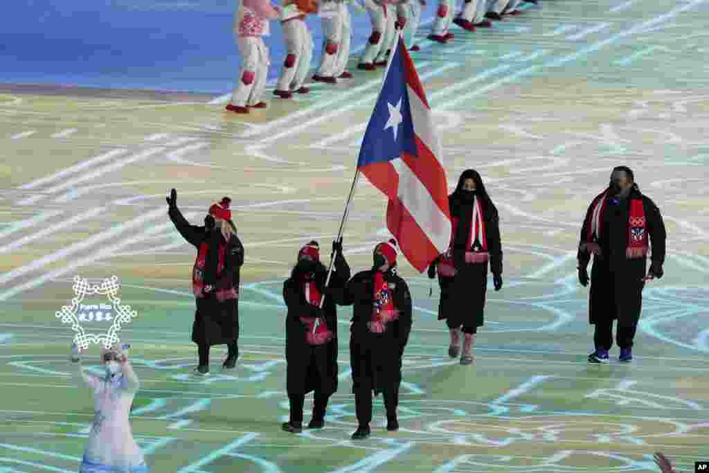 Kellie Delka y William C. Flaherty, de Puerto Rico, portan la bandera de su país.